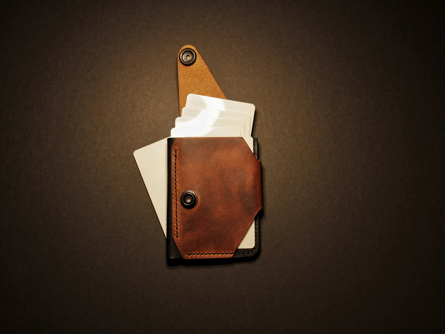 Brown leather wallet with card holder on a black background
